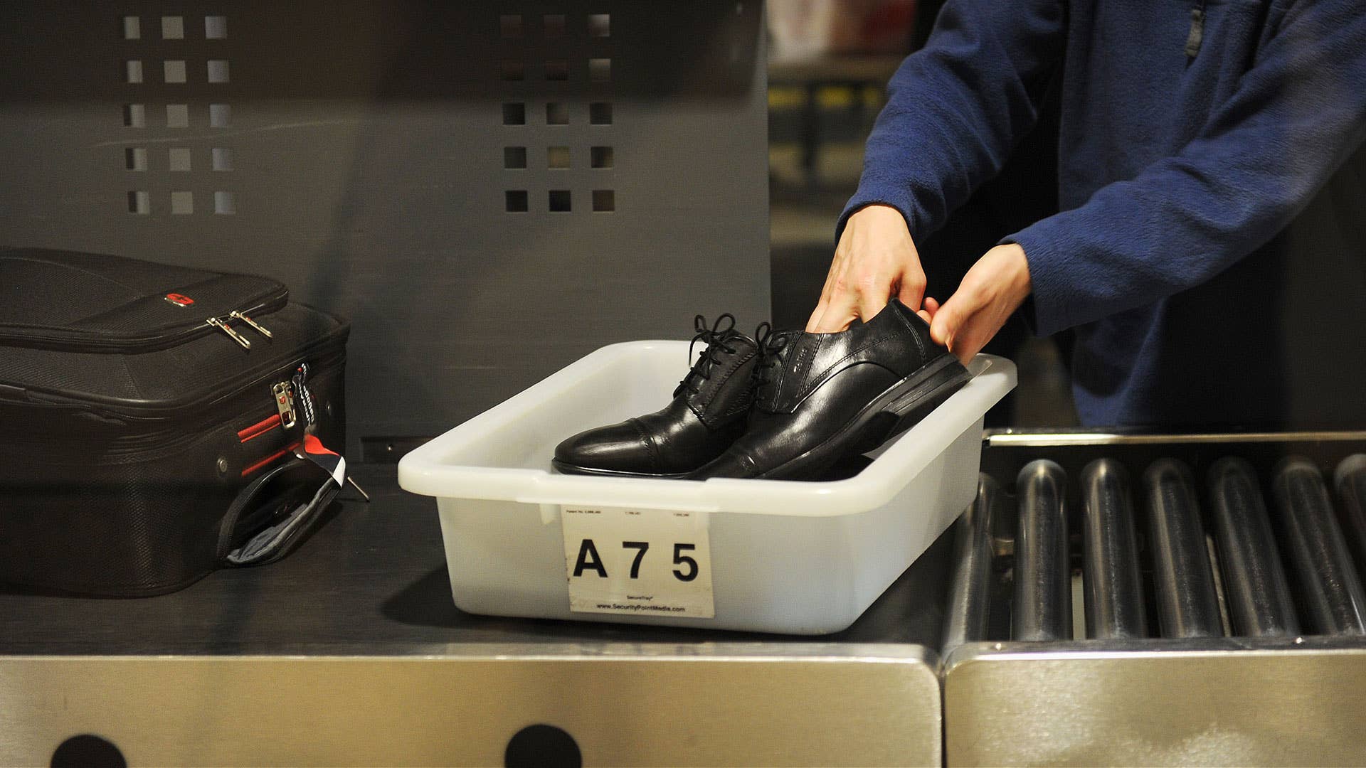 Passenger sending shoes through TSA inspection at airport. Lead.