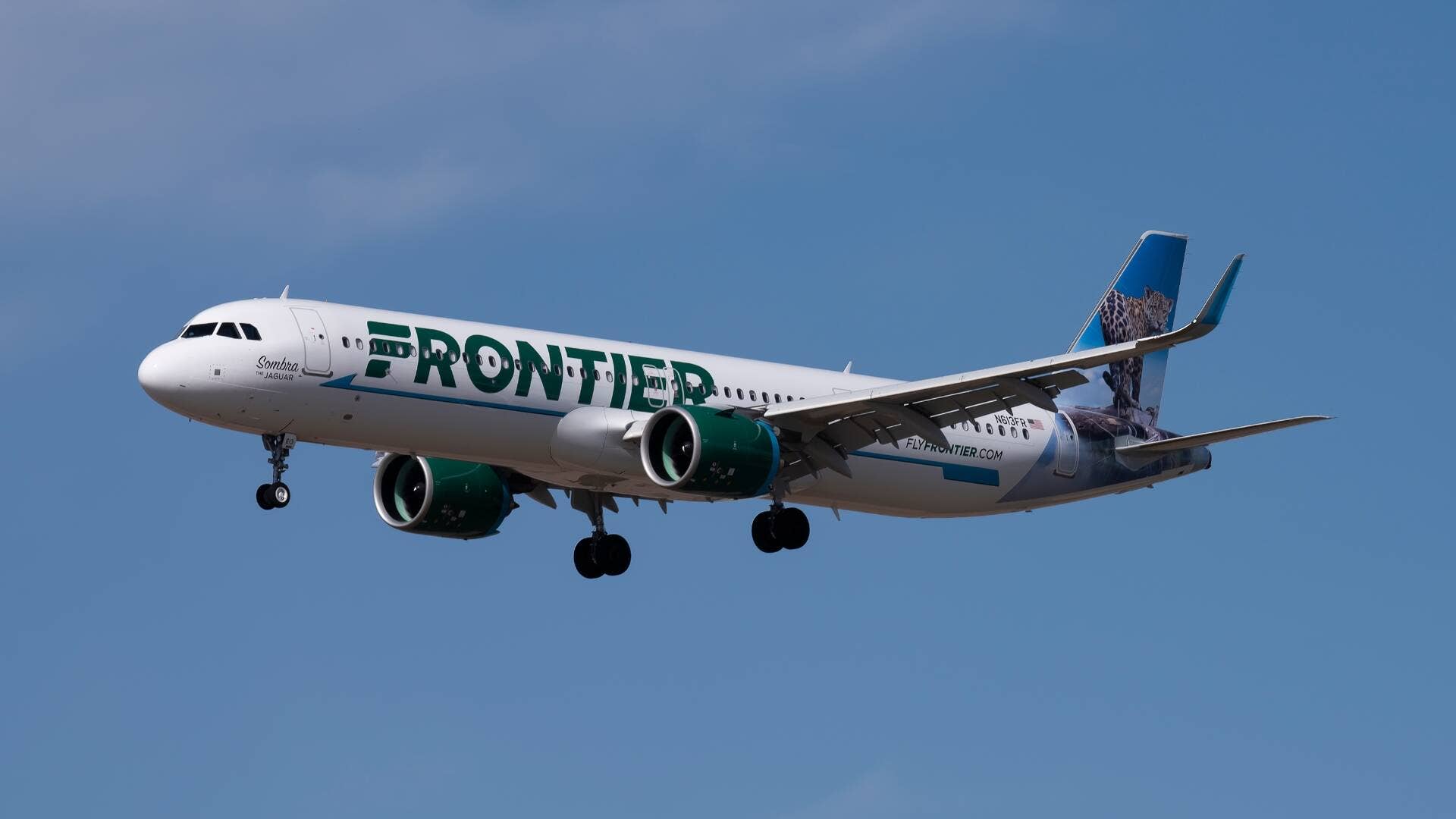 A Frontier Airlines airplane is seen in flight. -lead