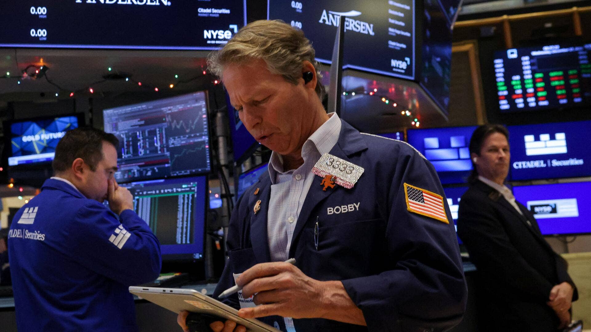A trader looks at his tablet on the floor of the New York Stock Exchange.