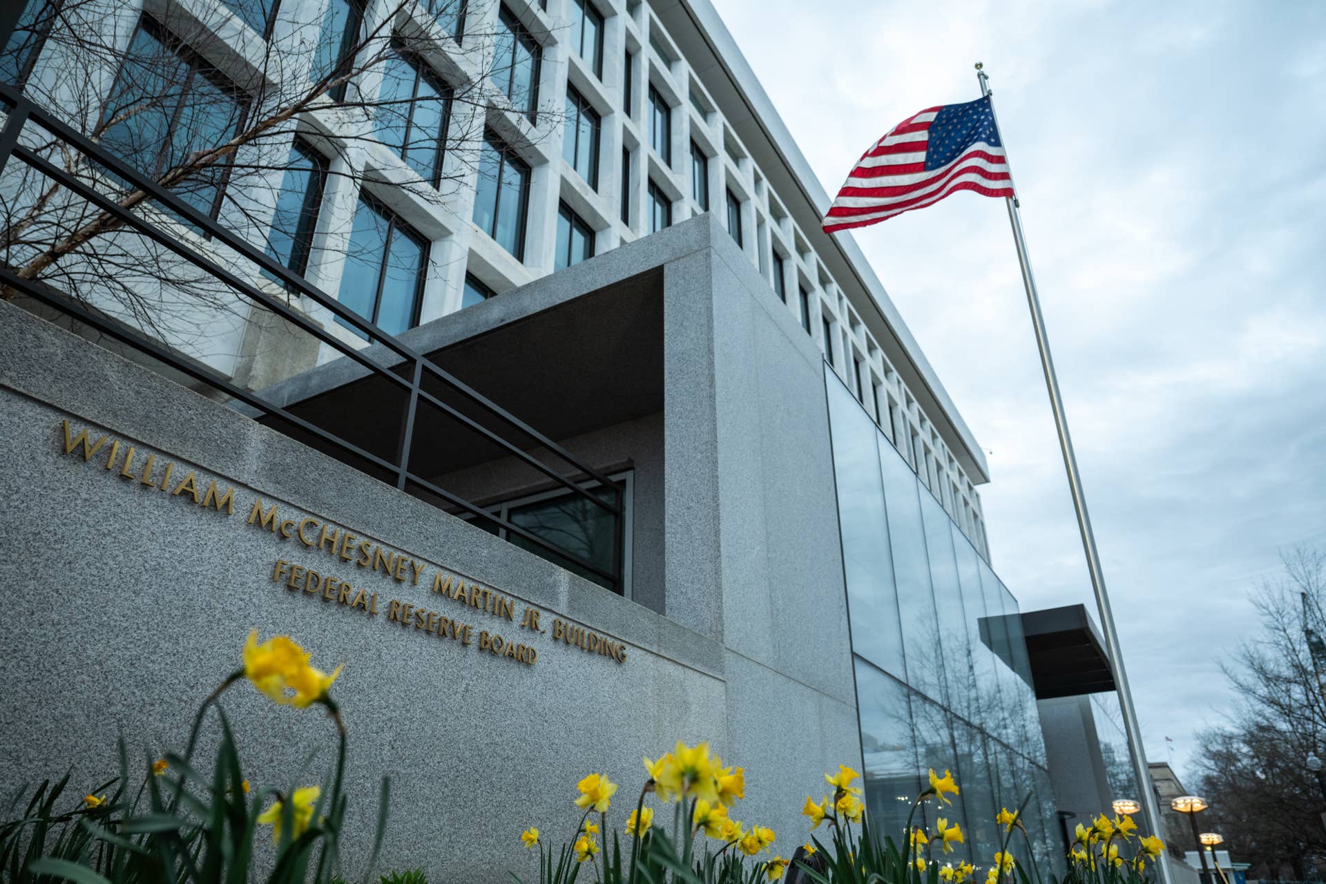 The William McChesney Martin Jr. Building of the Federal Reserve is shown with an American flag flying outside, illustrating its significance in U.S. monetary policy and interest rate management.