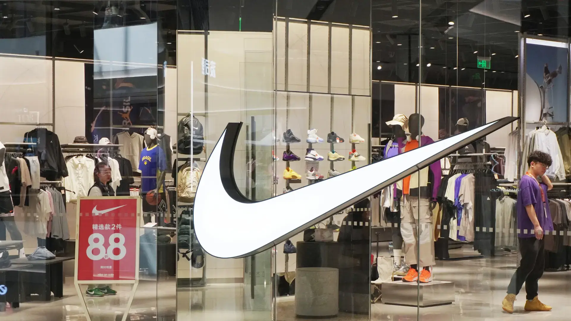A Nike store in Changzhou MixC displays a large illuminated swoosh logo.