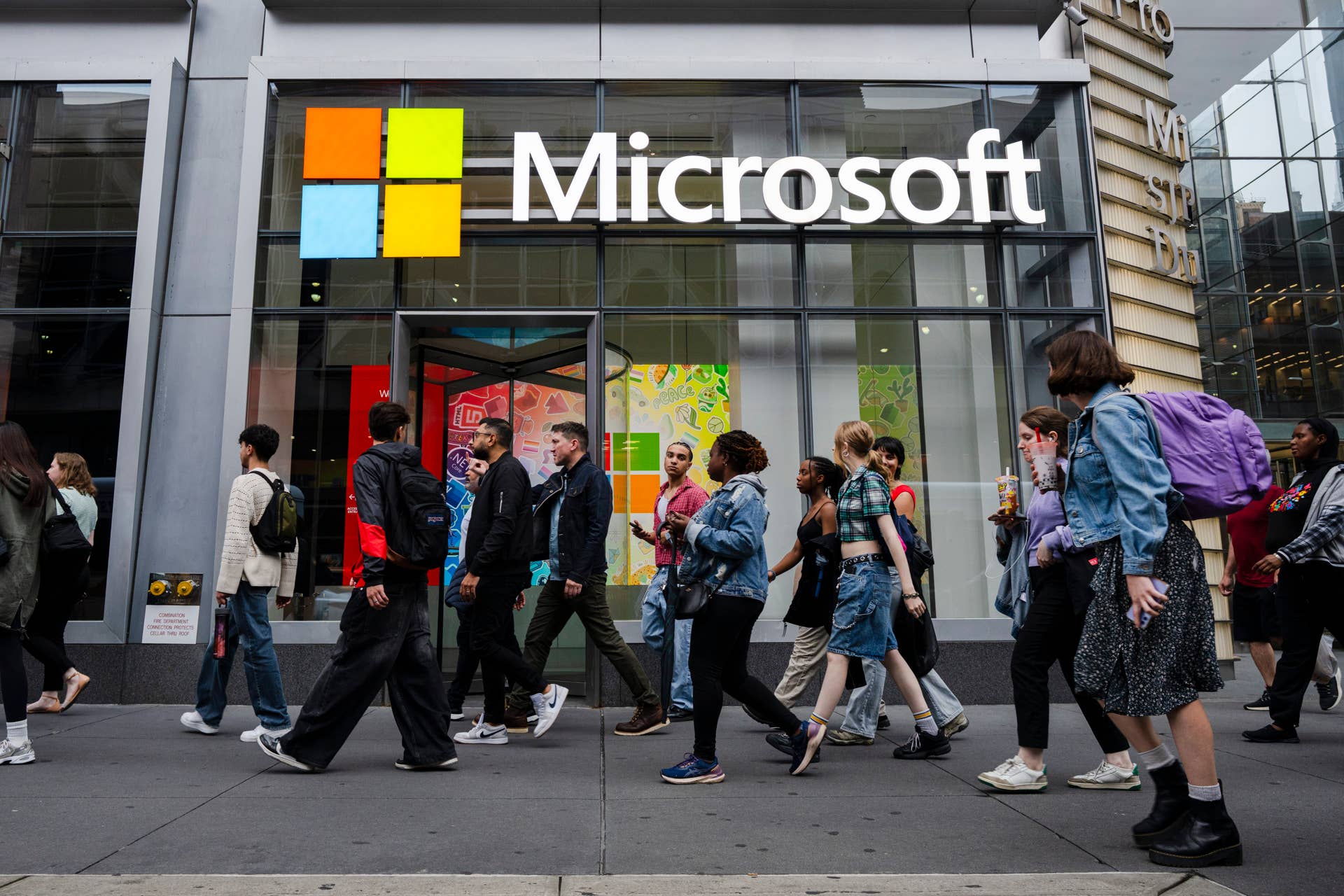 People walk by the Microsoft Office building on 41st street and 8th avenue in New York City.