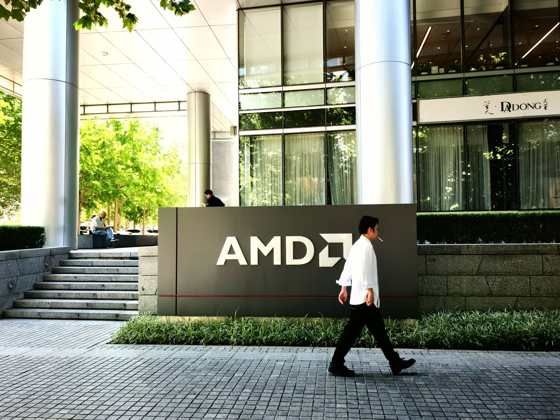 A passerby walking in front of AMD building