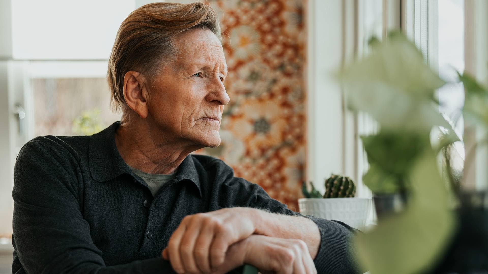 Retired man sitting by a window