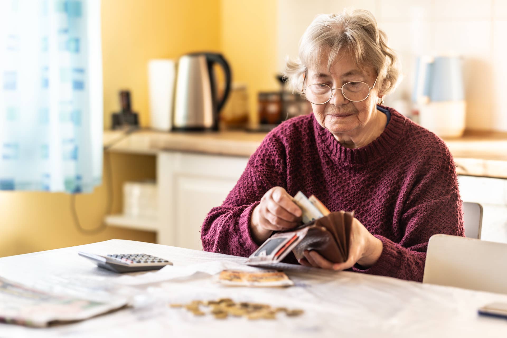 Older woman putting money in a wallet