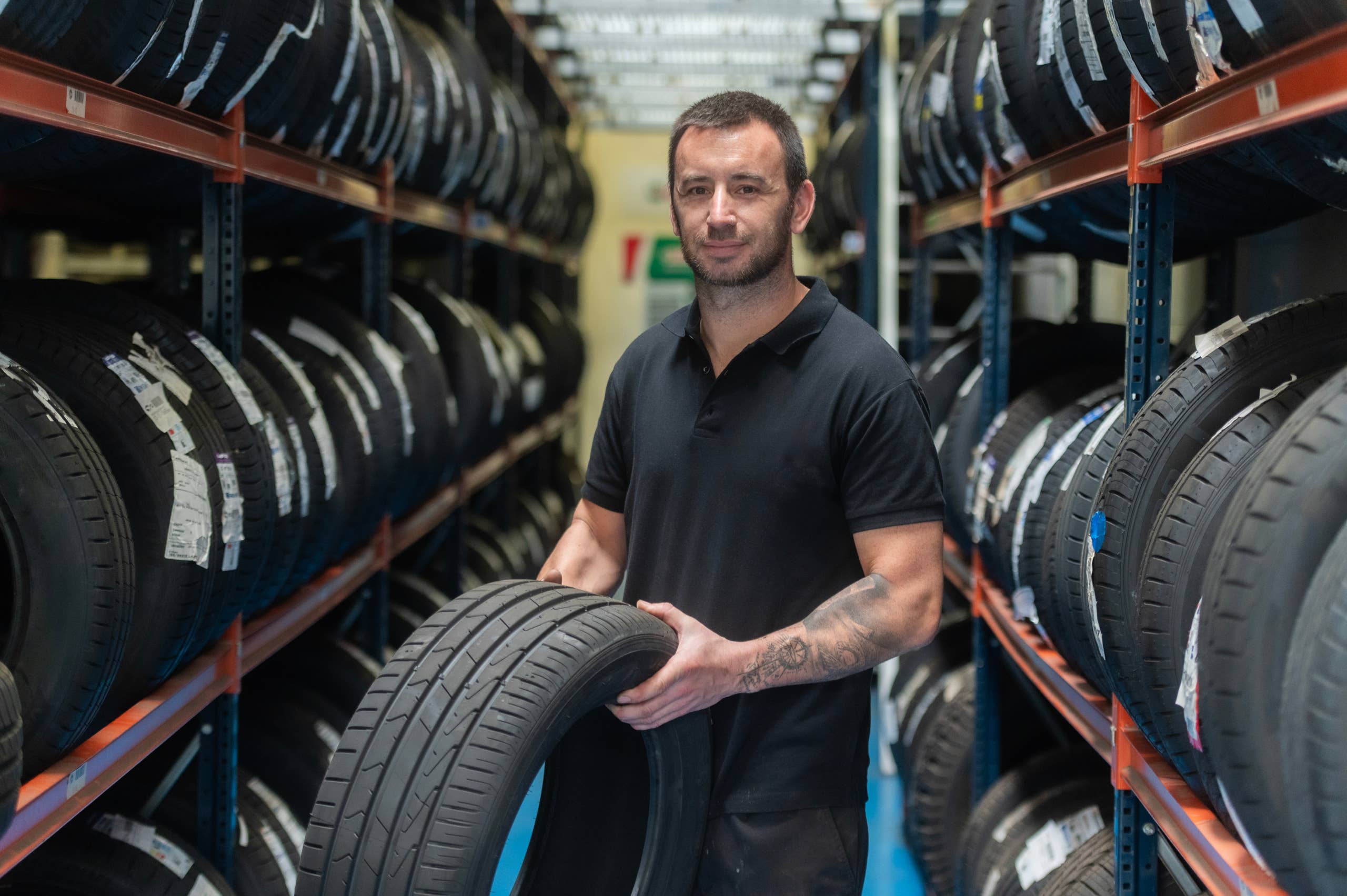 Tire shop worker examines inventory.
