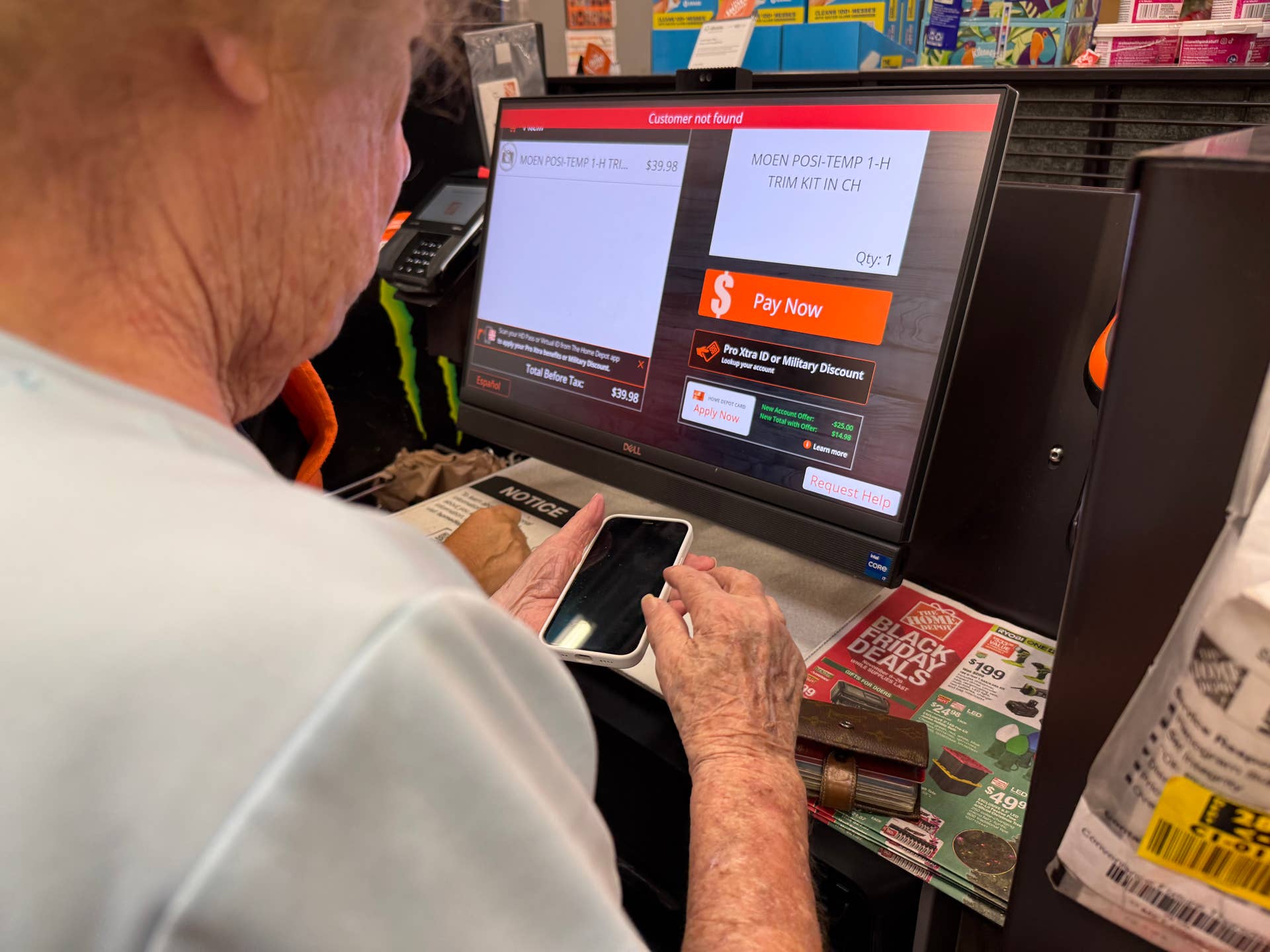Senior customer at Home Depot using self-checkout terminal, Palm Beach Gardens, Florida.