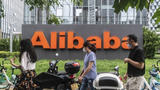 Pedestrians walk past Alibaba Group Holding's logo, displayed in front of the e-commerce giant's offices in Beijing, on August 19. Photo: Bloomberg
