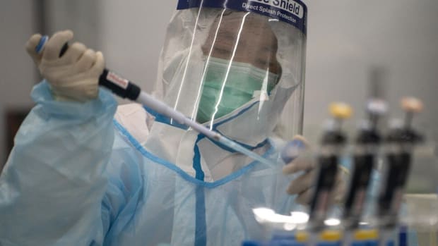 A lab technician wearing protective suit processes RT-PCR Covid-19 tests at Prenetics' laboratory in Hong Kong on Friday, July 31, 2020. Photo: Bloomberg