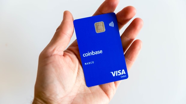 Photo of hand holding Coinbase debit card.