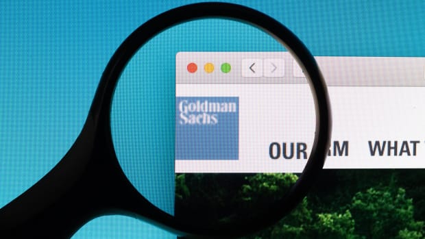 Goldman Sachs website logo under a magnifying glass.