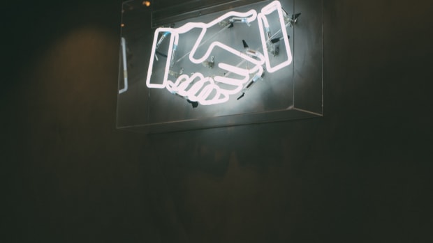 Neon sign showing a handshake.