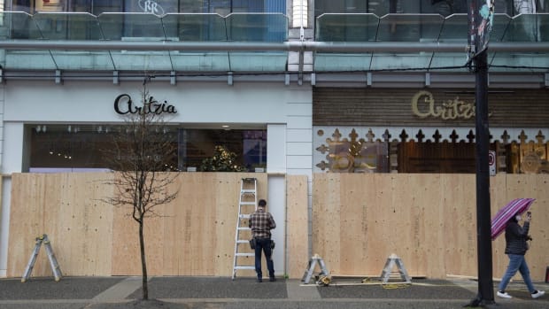 Workers board up an Aritzia clothing store on Robson Street in Vancouver on March 27. Photo: Bloomberg