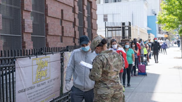 NEW YORK, NY - MAY 15, 2020: US Army National Guard hand out food and other essentials for people in need at a food pantry amid the COVID-19 pandemic on May 15, 2020 in Queens borough of New York City.