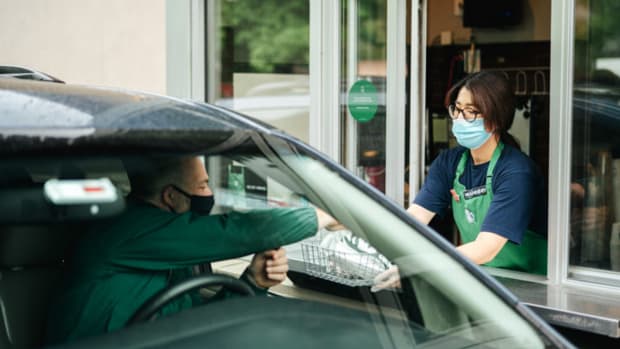 A man picks up an order at a Starbucks drive-through. Starbucks Customer Lead