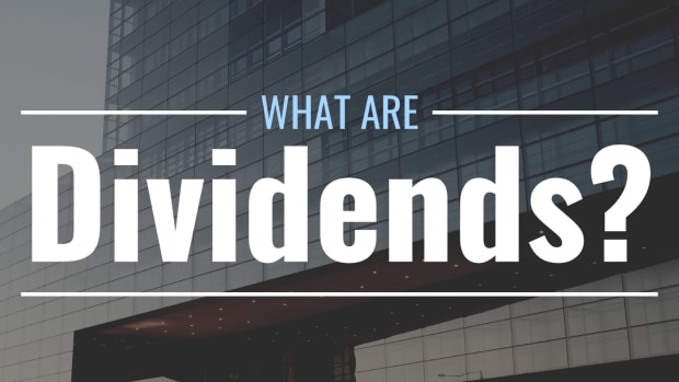 Darkened photo of a large office building with stylized text overlay that reads "What Are Dividends?"