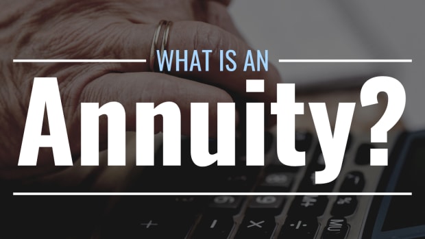 Darkened photo of a hand holding a pen and using a calculator with text overlay that reads "What Is an Annuity?"