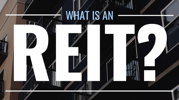 Darkened photo of an apartment complex from below with text overlay that reads "What Is an REIT?"