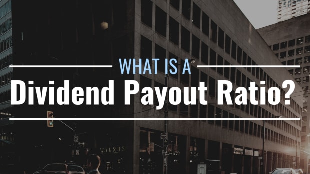 Darkened photo of a downtown city block with text overlay that reads "What Is a Dividend Payout Ratio"