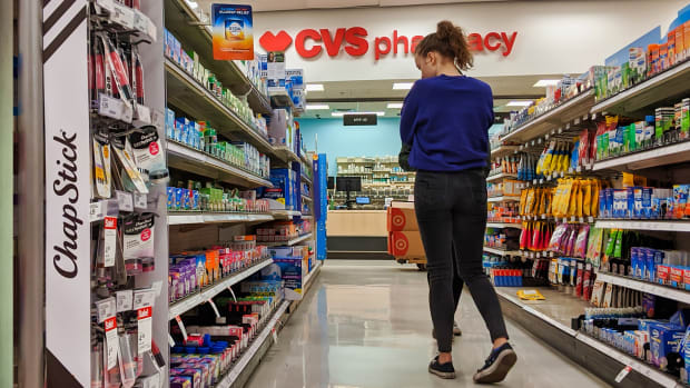 A woman shops an aisle in a CVS pharmacy. Lead.