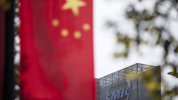 A Chinese flag seen near a logo atop the Semiconductor Manufacturing International Corp. (SMIC) headquarters in Shanghai, March 23, 2021. Photo: Bloomberg