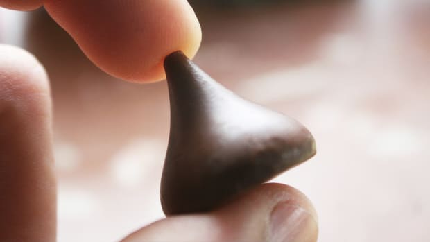A person holds a Hershey's Kiss. Lead.