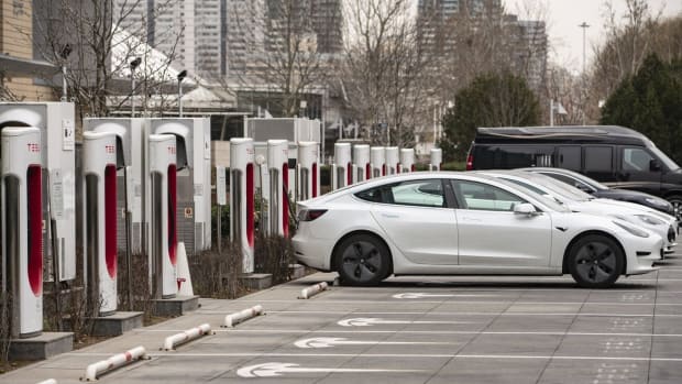 Tesla electric vehicles are parked next to charging stations outside one of the company's showrooms in Beijing. Photo: Bloomberg