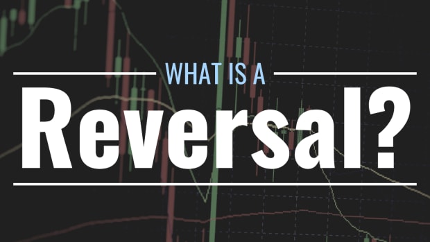 Darkened photo of a candlestick chart showing the volatile price action of an unknown asset with text overlay that reads "What Is a Reversal?"