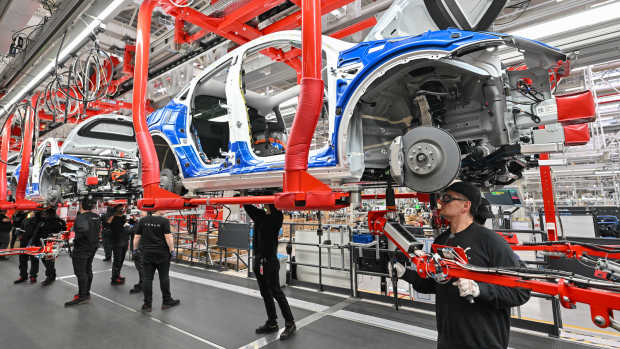 Employees of the Tesla Gigafactory Berlin Brandenburg work on a production line of a Model Y electric vehicle. The Tesla plant was opened and put into operation on March 22, 2022. In the meantime, about 10,000 people are employed there. (Photo by Patrick Pleul/picture alliance via Getty Images)