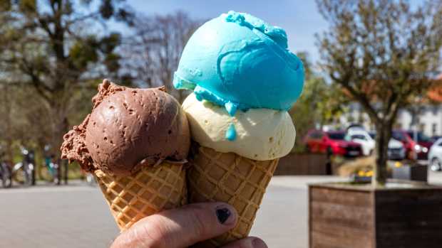 Two filled ice cream cones are held by a man's hand. (Photo by Frank Hammerschmidt/picture alliance via Getty Images)