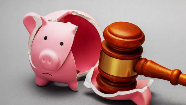 A gavel is seen smashing a piggy bank. Bankruptcy Lead DB.