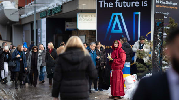 People in Switzerland walk past a sign promoting AI