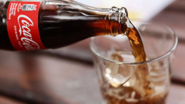 Coca-Cola is being poured into a glass. lead.