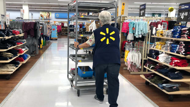 A Walmart employee pushing a cart..