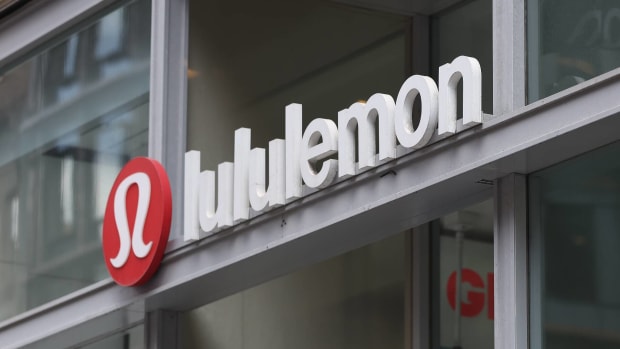 Close-up of the Lululemon store logo on a glass storefront.