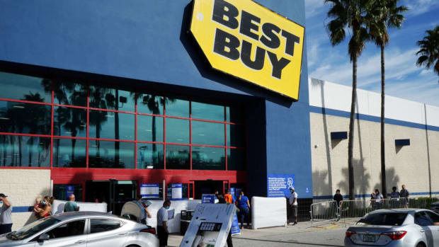 An employee brings a television to a customer's car at a Best Buy store.