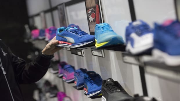 An employee arranges a Puma running shoe display inside the sportswear company's concept store at the Puma SE headquarters in Herzogenaurach, Germany, on Thursday, Feb. 9, 2017. Puma said operating profit in 2017 will rise at least as fast as last year, when three big global sports events and better sales of womens wear helped the measure jump by a third. Photographer: Alex Kraus/Bloomberg via Getty Images