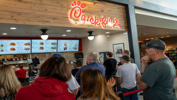 Customers stand in line to order food at a Chick-fil-A restaurant. lead.