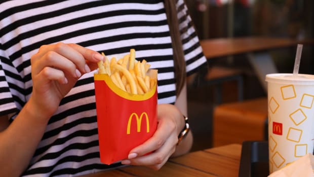 Woman with McDonald's French fries and drink. lead.