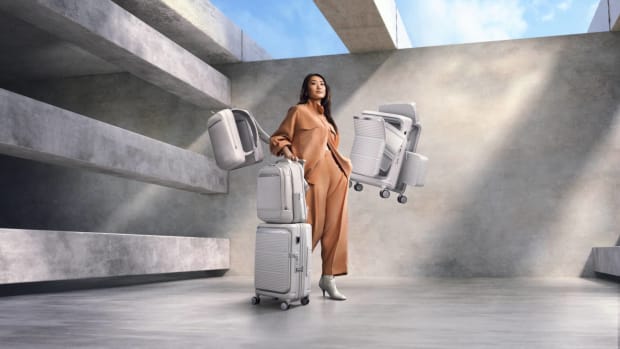 A woman holds luggage items and suitcases from the Samsonite Paralux Collection. lead.