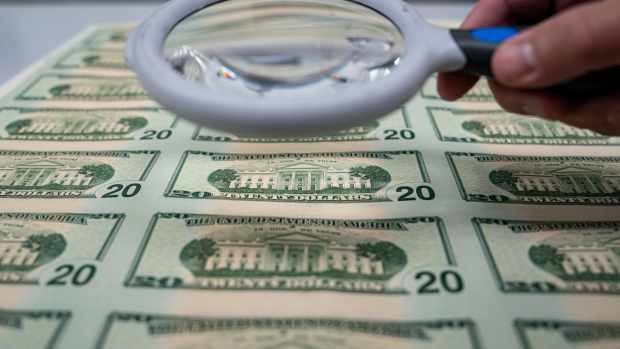 A worker holds a magnifying glass over a 50 subject $20 dollar note sheet after being printed by an intaglio printing press at the US Bureau of Engraving and Printing in Washington, DC, US, on Tuesday, May 21, 2024. Money-market fund assets rose as elevated short-term rates continued to lure funds, even after recent economic data suggests the Federal Reserve could ease monetary policy this year. Photographer: Al Drago/Bloomberg via Getty Images