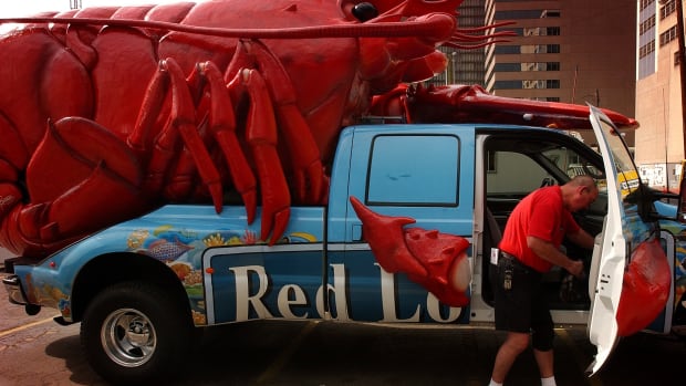 Mike Sears from Kansas City reaches in the glove box of the Ford pickup truck that hauls Red Lobster's 3000 pound fiberglass shell lobster named CLAWDE which will be on hand for this weekend's A Taste of Colorado festival in downtown Denver. Sears works for a promotional company that represents Red Lobster. CLAWDE was parked in a lot at Cheyenne Place and Broadway. Sears gets to drive the crustacean across the country. A Taste of Colorado starts tommorrow on Friday, August 31, 2001.  (Photo By Cyrus McCrimmon/The Denver Post via Getty Images)