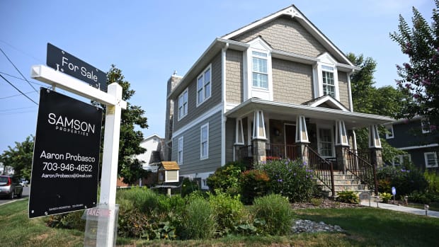 A "for sale" sign in front of a home.