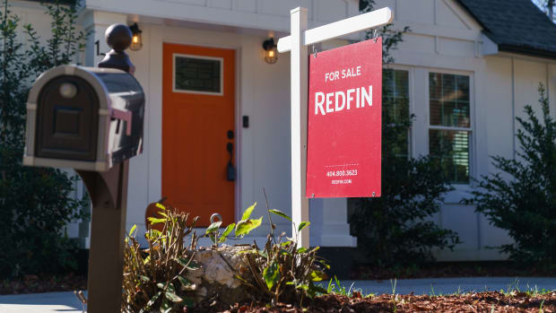 A Redfin sign in front of a home for sale in Atlanta on Sunday, Nov. 13, 2022. Redfin is shuttering its iBuying business and laying off workers for the second time in almost five months, as the likelihood of a prolonged U.S. housing slowdown continues to ripple through the industry.
