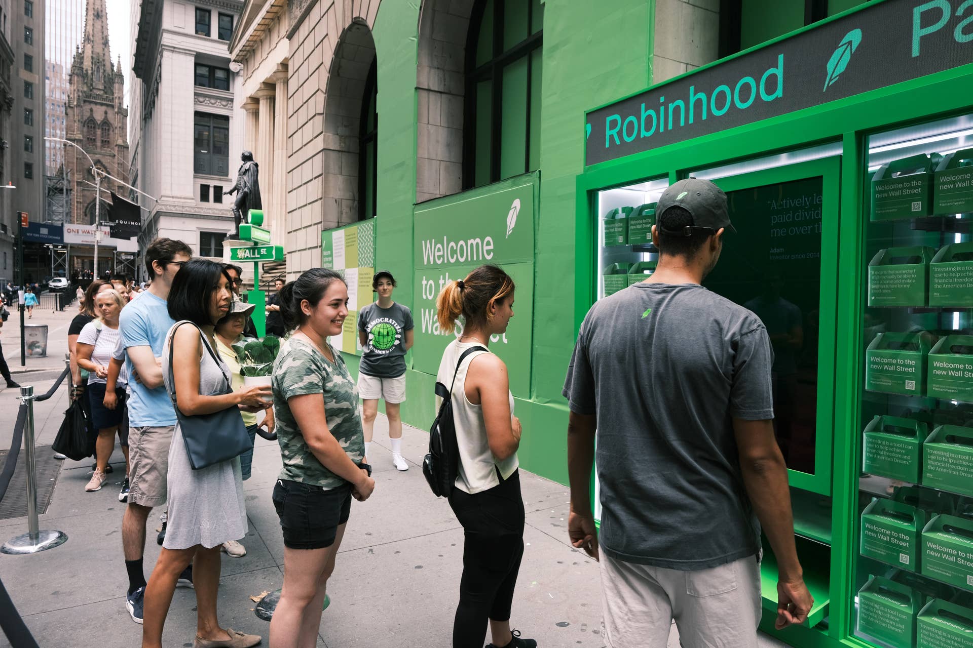 People wait in line for t-shirts at a pop-up kiosk for the online brokerage Robinhood along Wall Street after the company went public with an IPO earlier in the day on July 29, 2021 in New York City.