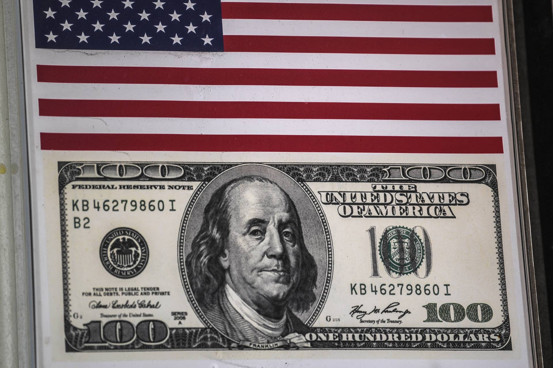 This picture taken on August 2, 2018 in Istanbul shows a US national flag and a 100 US dollars banknote sticker at a money exchange office at Istiklal avenue.