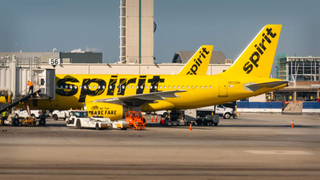 A Spirit Airlines plane sits at the terminal. -lead