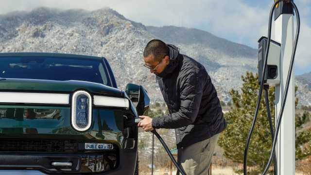 A Rivian owner uses a Rivian-branded EV charger