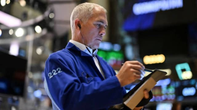 A trader on the New York Stock Exchange NYSE floor is looking at a tablet. lead.