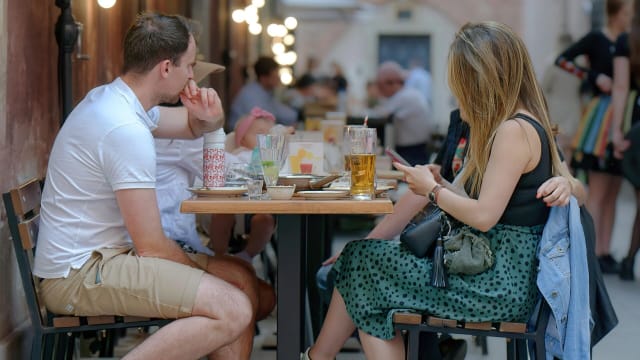 A man and a woman are eating at a table. lead.